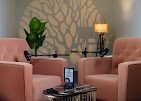 The interview set dressed with tan armchairs, a lamp and plants