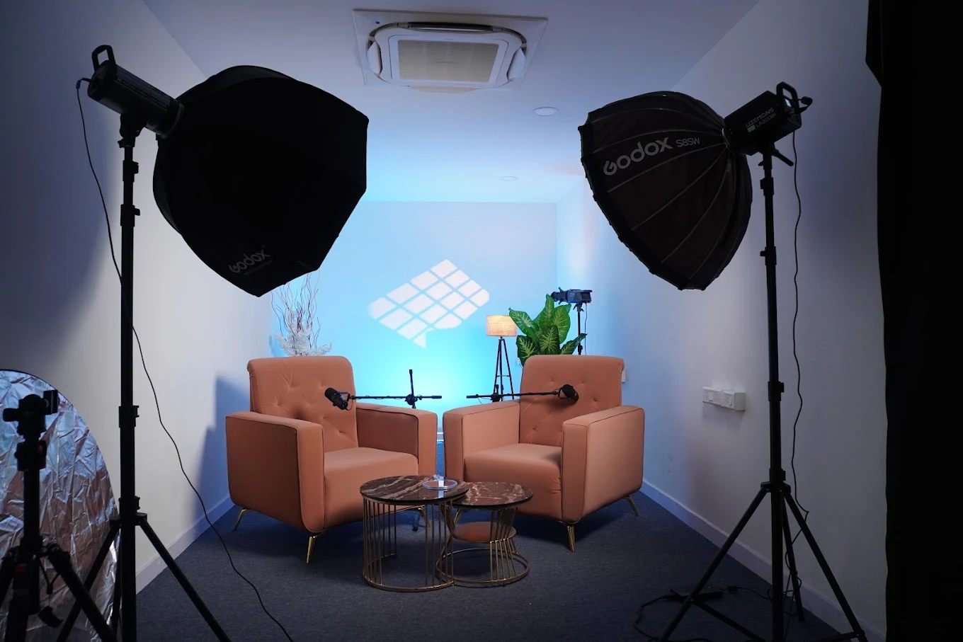 Two hosts recording a podcast episode on the Virtuatainment set